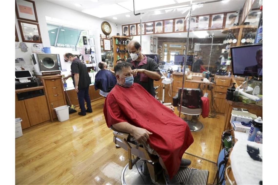 Kunden sitzen in einem New Yorker Friseurladen. Foto: Wang Ying/XinHua/dpa