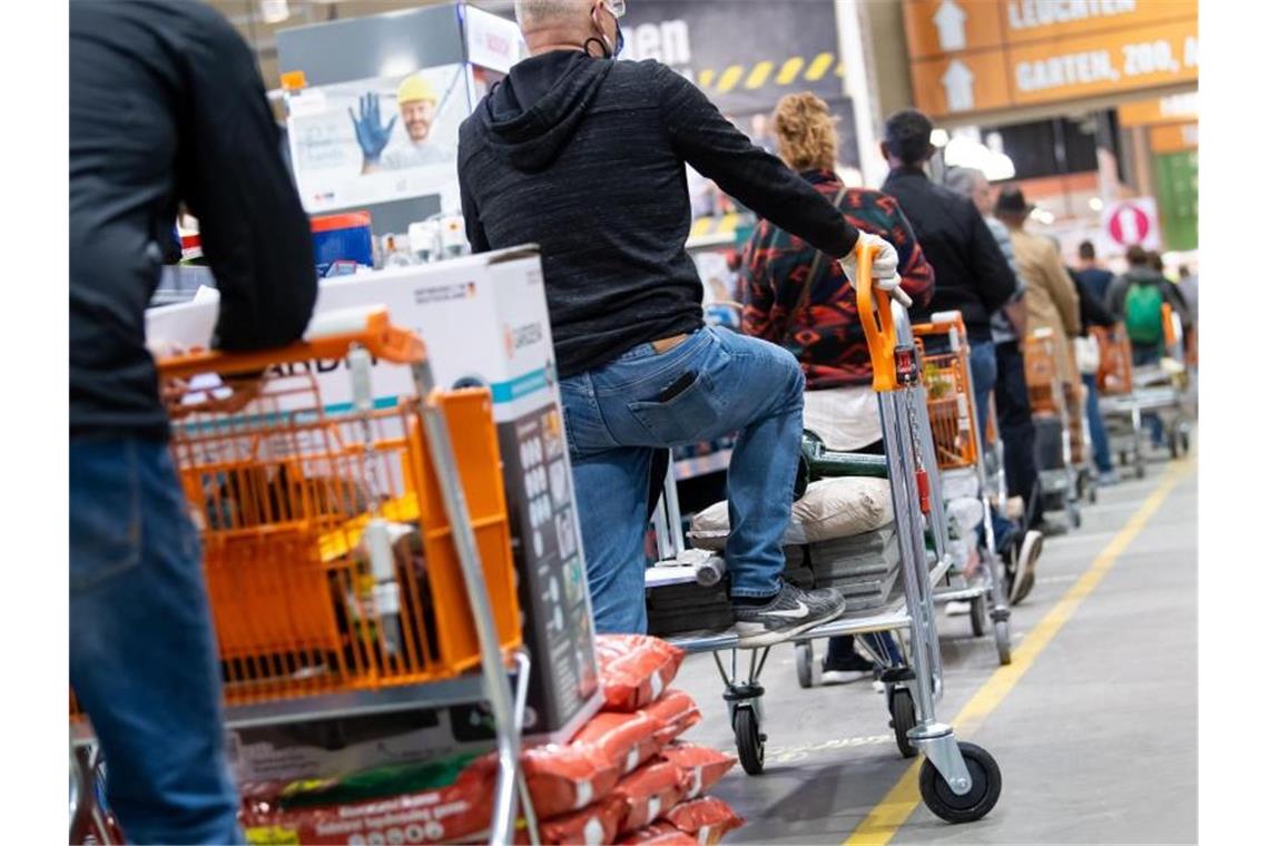 Lieferengpässe treffen Deutschlands Baumärkte Kunden stehen mit Einkaufswagen in einem Baumarkt in einer Schlange vor den Kassen an. Die globalen Verwerfungen in den Lieferketten setzen Deutschlands Bau- und Gartenmärkte unter Druck. Foto: Sven Hoppe/dpa