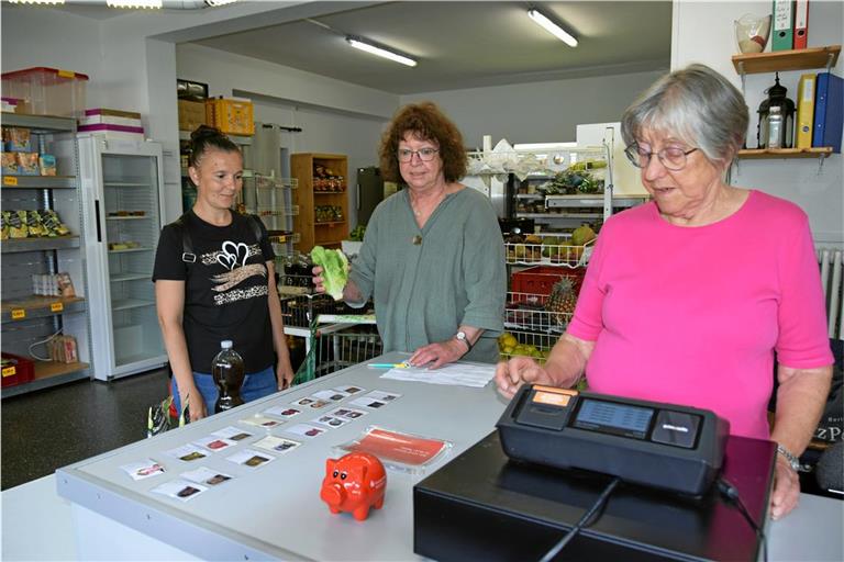 Kundin Marianqa Kostiak (links) schaut zu, wie das Zweierteam an der Kasse zusammenarbeitet – Andrea Klenk (Mitte) schaut nach dem Preis und Renate Göckler gibt ihn ein. Foto: Elisabeth Klaper