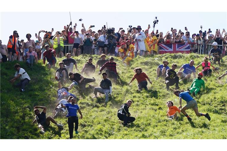 Kurioser Kultlauf in Gloucestershire: Beim Käserennen 2026 rennen Männer dem rollenden Käselaib den Hügel hinunter nach.