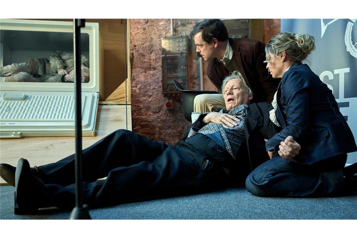 Kurt Hobrecht sen. (Hannes Hellmann, Mitte) bricht beim Anblick der schockgefrorenen Leiche in der First-Bike-Präsentationskiste zusammen. Sohn Konstantin (Franz Hartwig, l.) und Tochter Klara (Karolina Lodyga, r.) eilen ihm zur Hilfe.