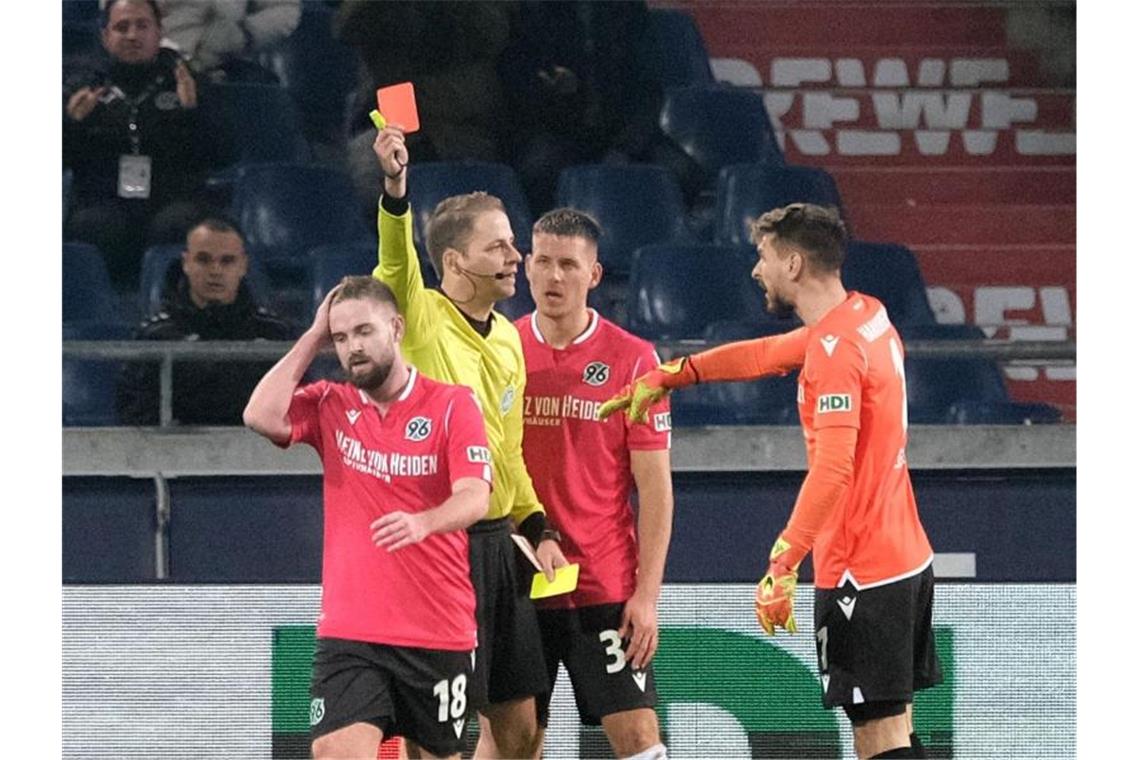 Kurz nach seinem nicht gewerteten Treffer sah der verhinderte Torschütze von Hannover 96 auch noch rot: Schiedsrichter Martin Thomsen (2.v.l) zeigt Marc Stendera (l) die Karte. Foto: Peter Steffen/dpa