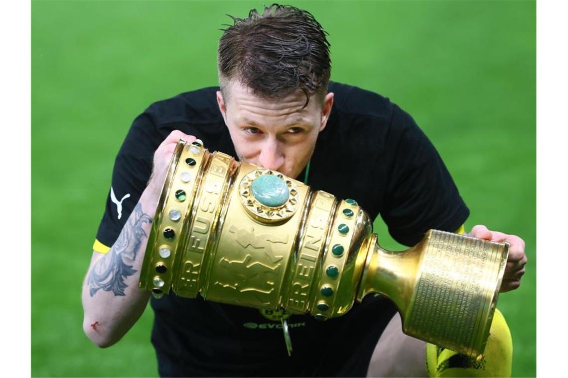 Zaubern statt Zaudern: BVB-Kapitän Reus in alter Form Kuss für den Pott: Marco Reus feiert den Pokalsieg. Foto: Martin Rose/Getty-Pool/dpa