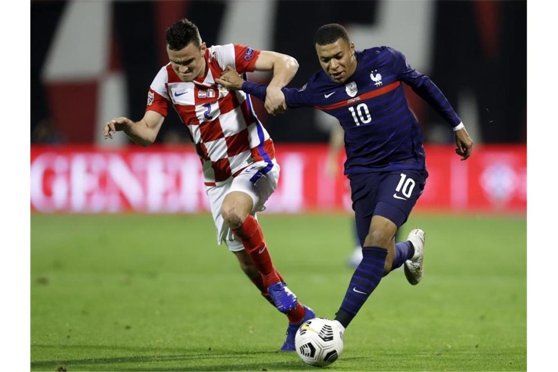 Kylian Mbappe (r) von Frankreich in Aktion gegen den Kroaten Filip Uremovic. Foto: Darko Bandic/AP/dpa