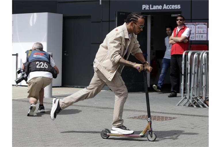 Läuft sich auf der Rennstrecke von Silverstone mit einem Roller warm: WM-Spitzenreiter Lewis Hamilton. Foto: Luca Bruno/AP