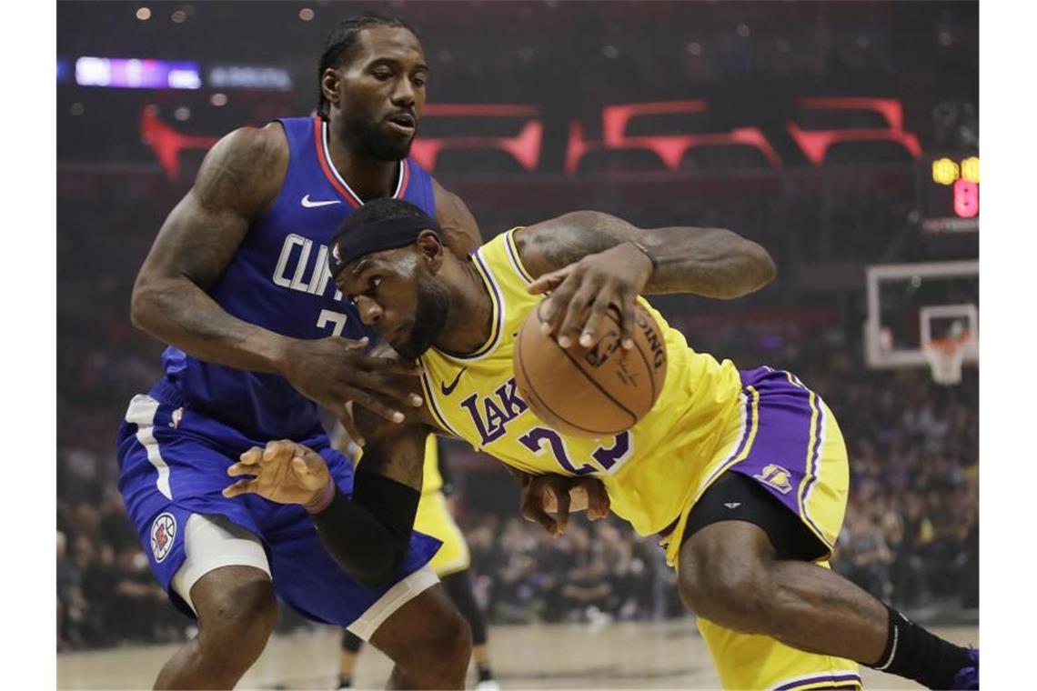 Lakers-Superstar LeBron James im versucht an Kawhi Leonard (l) von den Los Angeles Clippers vorbeizukommen. Foto: Marcio Jose Sanchez/AP/dpa