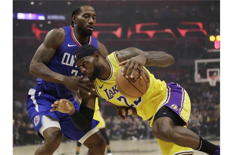 Lakers-Superstar LeBron James im versucht an Kawhi Leonard (l) von den Los Angeles Clippers vorbeizukommen. Foto: Marcio Jose Sanchez/AP/dpa