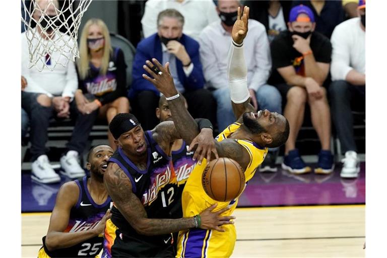 Lakers-Superstar LeBron James (r) wird von der Defense der Phoenix Suns gestoppt. Foto: Matt York/AP/dpa