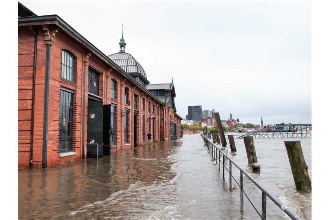 Land unter: Der Fischmarkt mit der Fischauktionshalle ist überschwemmt. Foto: Daniel Bockwoldt/dpa