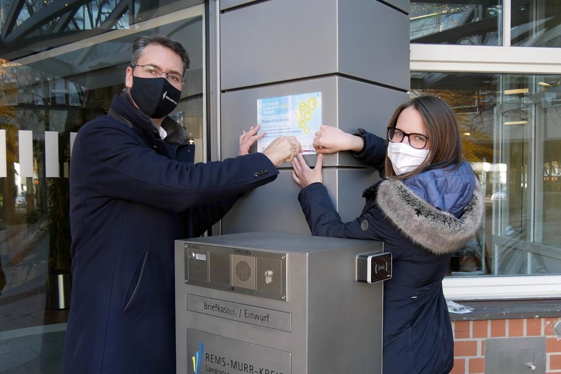 Kreis erhält Klimaschutz-Bundespreis Landrat Richard Sigel und Felicia Wurster, Leiterin der Geschäftsstelle Klimaschutz im Landratsamt, bringen die Plakette mit der Auszeichnung als „Klimaaktive Kommune“ an. Foto: Landratsamt