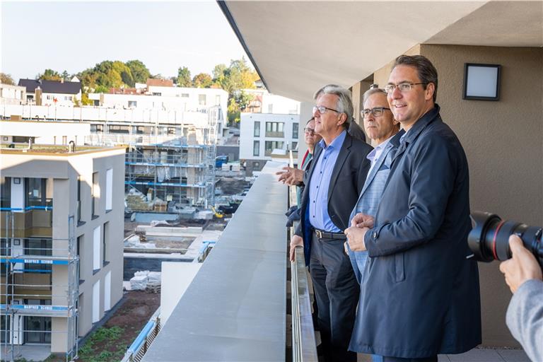 Landrat Richard Sigel (von rechts), Kreisbau-Geschäftsführer Dirk Braun und Waiblingens Oberbürgermeister Andreas Hesky blicken vom Balkon einer der 40 neuen Wohnungen auf die entstehenden Neubauten auf dem alten Waiblinger Klinikareal.  Foto: Kreisbaugruppe