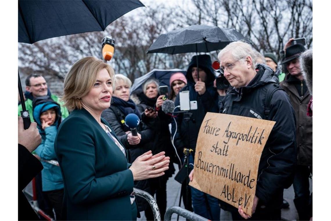 Merkel lehnt staatliche Eingriffe in Lebensmittelpreise ab Landwirtschaftsministerin Julia Klöckner diskutiert mit den Demonstranten. Foto: Michael Kappeler/dpa