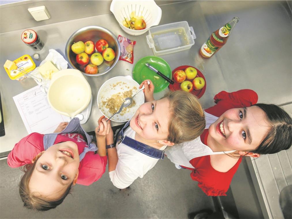 Lara, Janina und Jayne (von rechts) sind für die Süßspeisen zuständig. Während sie die Bratäpfel zubereiten, duftet es aus dem Ofen herrlich nach Quarkbrötchen. Fotos: A. Becher