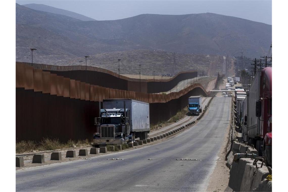 Lastwagen an einem Grenzzaun in Tijuana. US-Präsident Trump hatte angedroht, von Montag an Zölle in Höhe von fünf Prozent auf alle Wareneinfuhren aus Mexiko zu erheben. Die beiden Nachbarländer konnten sich nun zunächst einigen. Foto: Hans-Maximo Musielik/AP