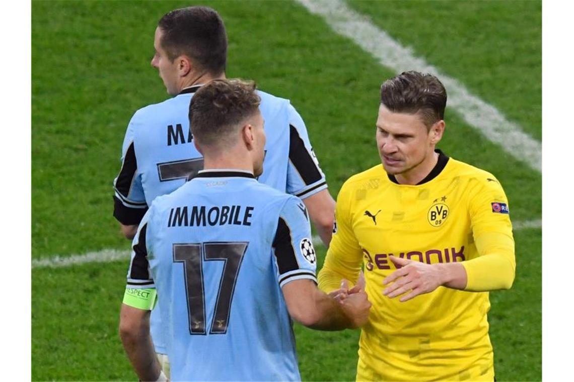 Lazios Ciro Immobile (l) und Dortmunds Lukasz Piszczek verabschieden sich nach dem Spiel. Foto: Bernd Thissen/dpa-Pool/dpa