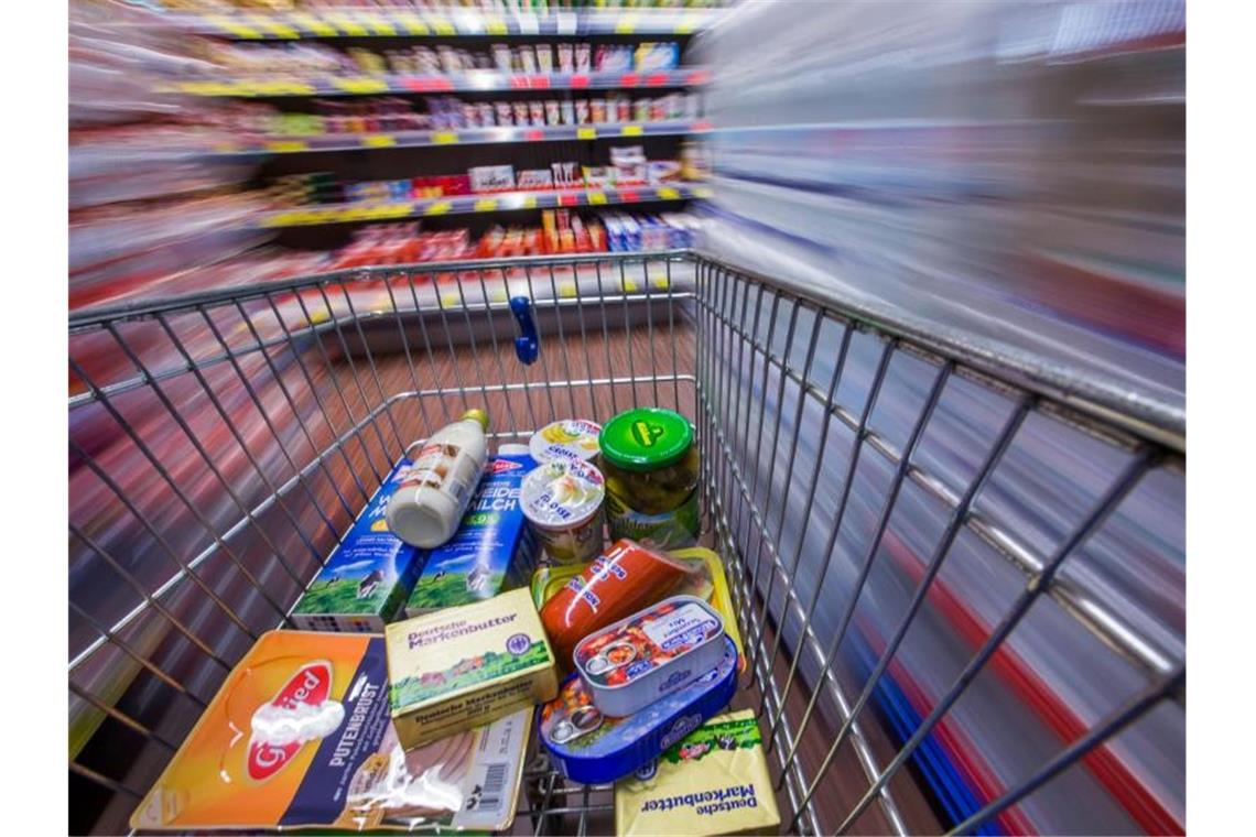 Lebensmittel in einen Einkaufswagen. Foto: Jens Büttner/dpa-Zentralbild/dpa