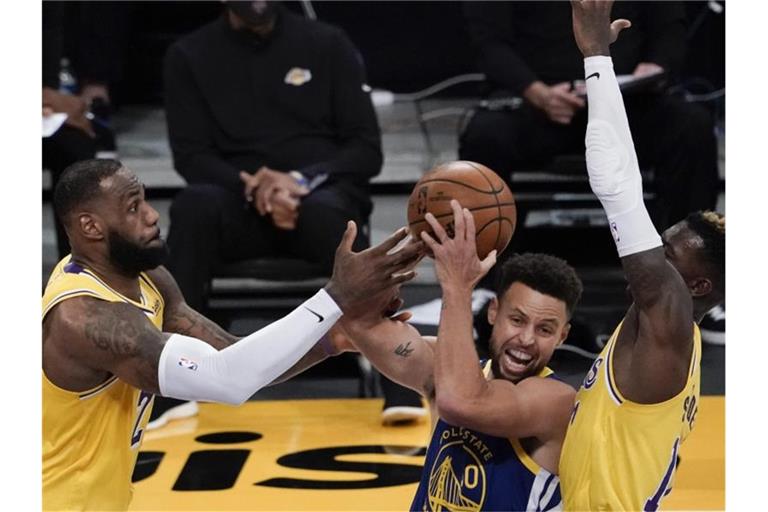 LeBron James (l) und Dennis Schröder (r) setzten sich mit den Los Angeles Lakers gegen Stephen Curry und die Golden State Warriors durch. Foto: Jae C. Hong/AP/dpa