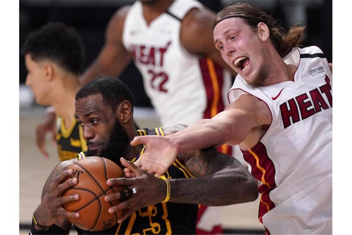 LeBron James (l/23) von den Los Angeles Lakers setzt sich gegen Kelly Olynyk (r/9) von Miami Heat durch. Foto: Mark J. Terrill/AP/dpa
