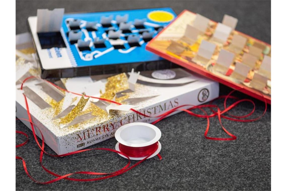 Adventskalender verursachen viel Verpackungsmüll Leere Adventskalender liegen zusammen mit einer Rolle Geschenkband auf dem Boden. Foto: Lucas Bäuml/dpa