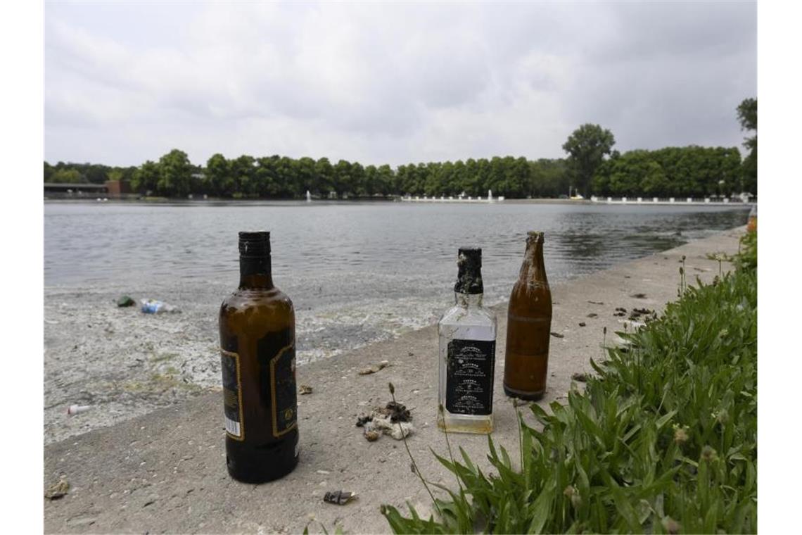 Leere Flaschen sind die letzten Überreste einer Party am Aachener Weiher in Köln. Foto: Roberto Pfeil/dpa