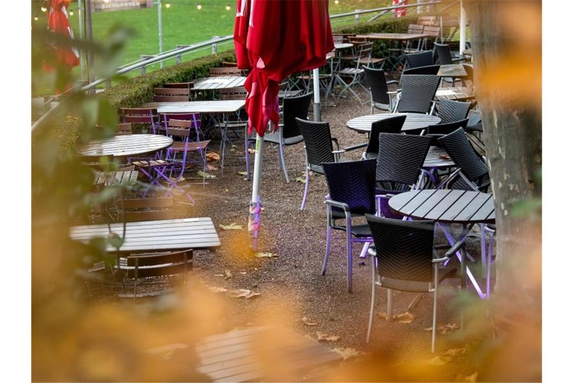 Leere Tische und Stühle stehen vor einem Restaurant. Foto: Sina Schuldt/dpa