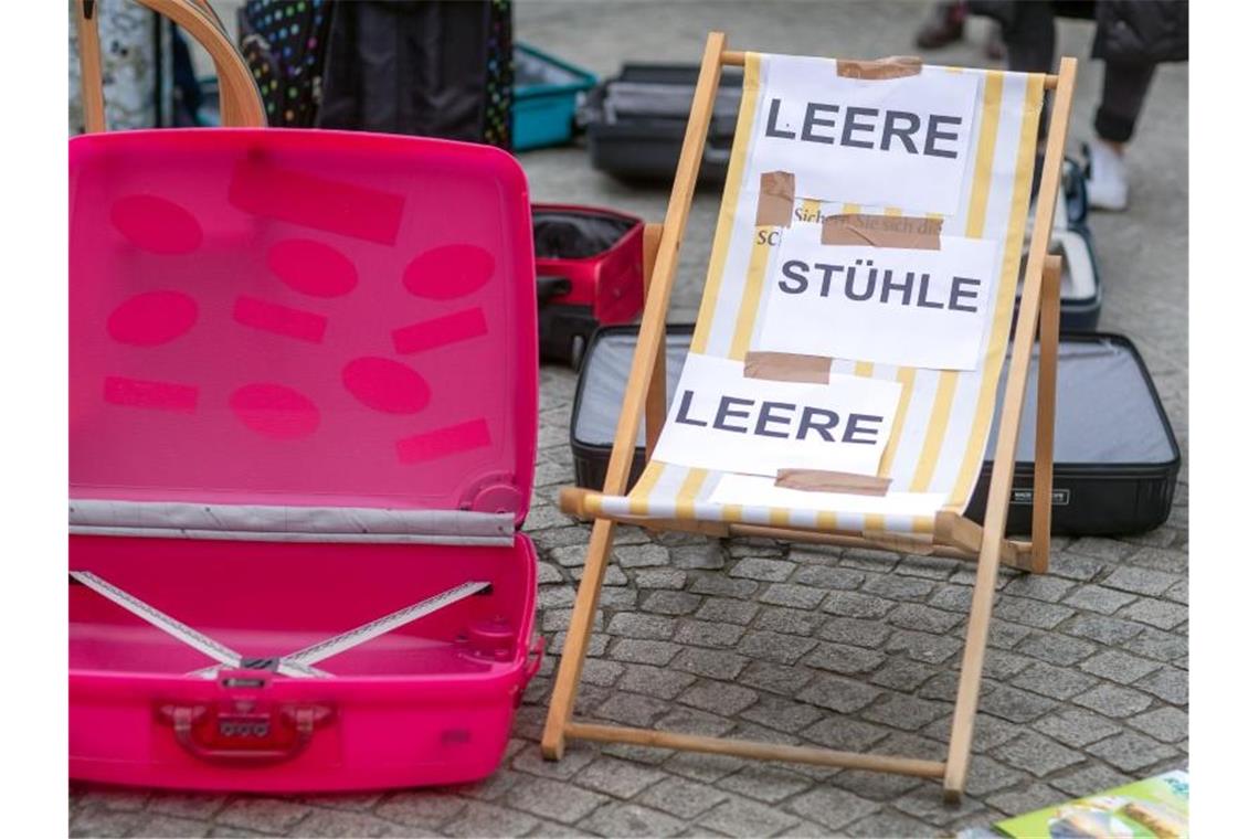 Mitarbeiter von Reisebüros demonstrieren für Rettungsschirm Leeren Koffer und Liegestühle bei einer Demonstration. Foto: Jens Büttner/dpa-Zentralbild/dpa