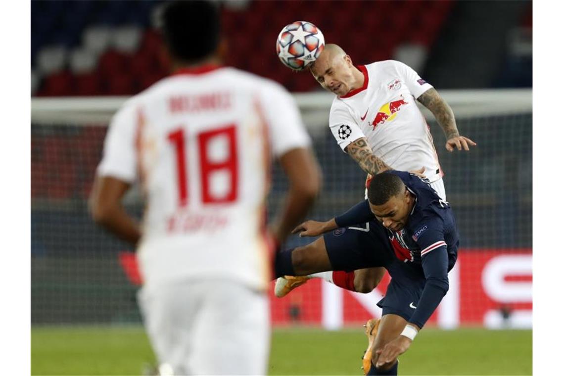 Leipzigs Angelino (r) setzt sich gegen Weltmeister Kylian Mbappe durch. Foto: Thibault Camus/AP/dpa