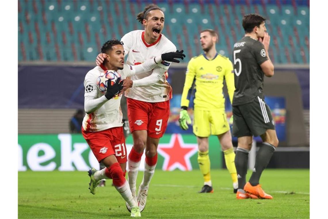 Leipzig im Achtelfinale: RB besiegt Manchester United Leipzigs Justin Kluivert (l) jubelt nach seinem Tor zum 3:0 mit Yussuf Poulsen. Dahinter Manchesters Torwart David de Gea (2.v.r.) und Harry Maguire (r). Foto: Jan Woitas/dpa-Zentralbild/dpa