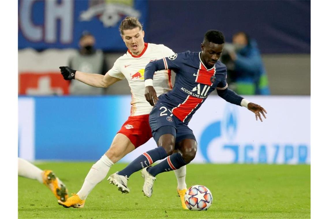 Leipzigs Marcel Sabitzer (l) und Idrissa Gueye von PSG kämpfen um den Ball. Foto: Jan Woitas/dpa-Zentralbild/dpa