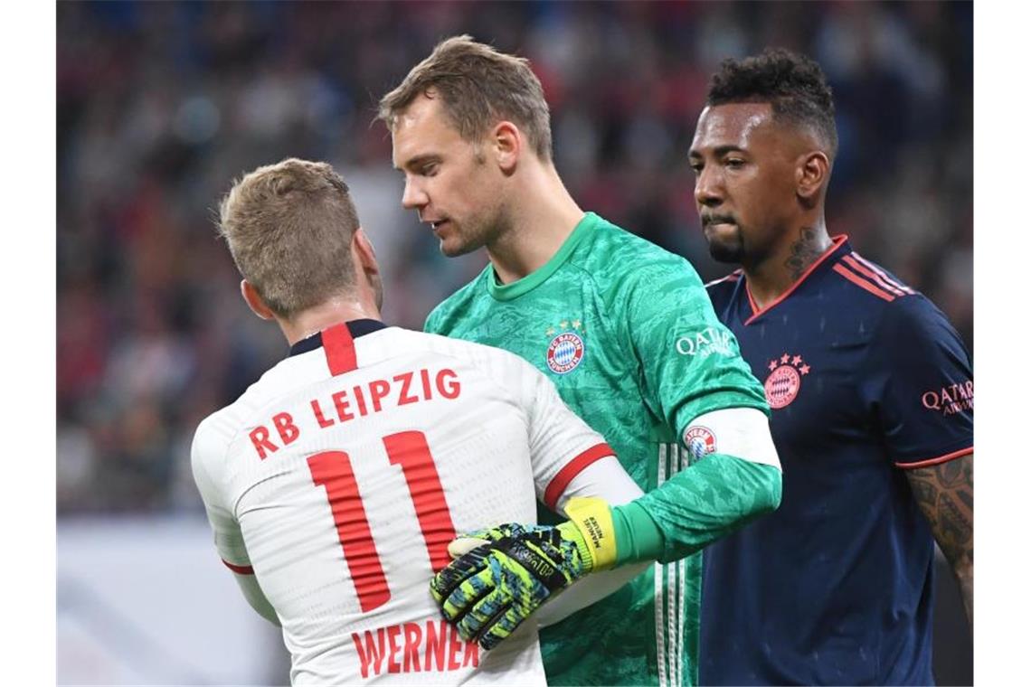 Leipzigs Timo Werner (l) im Gespräch mit Bayerns Torwart Manuel Neuer (M) und Jerome Boateng (r). Foto: Hendrik Schmidt/dpa-Zentralbild/dpa