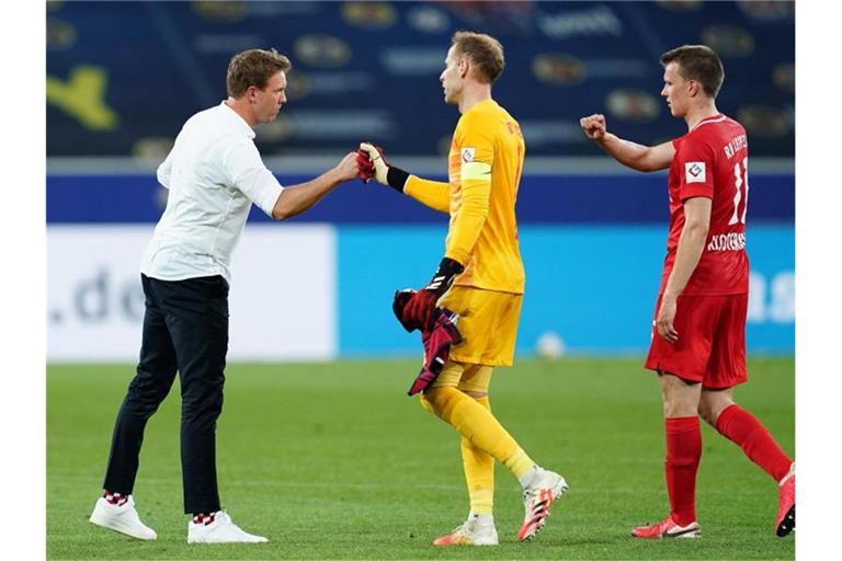 Leipzigs Trainer Julian Nagelsmann (l) klatscht sich nach dem Sieg mit Torwart Peter Gulacsi (M.) und Lukas Klostermann ab. Foto: Uwe Anspach/dpa-Pool/dpa