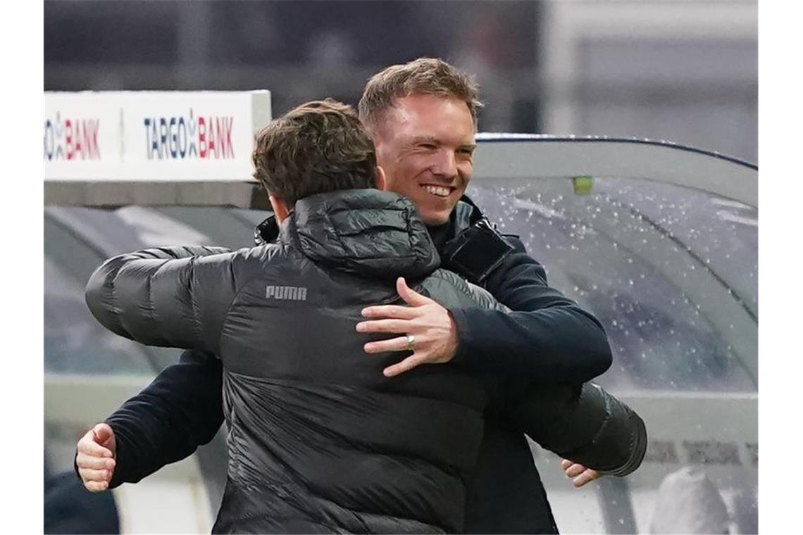 Leipzigs Trainer Julian Nagelsmann und Dortmunds Trainer Edin Terzic (l) begrüßen sich herzlich vor dem Spiel. Foto: Michael Sohn/AP-Pool/dpa