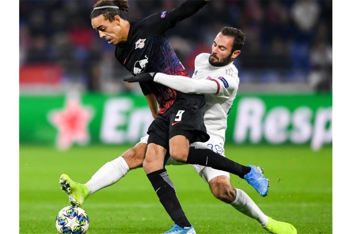 Leipzig als Gruppensieger ins Achtelfinale Leipzigs Yussuf Poulsen (l) wird beim Kampf um den Ball vom Lyoner Lucas Tousart gehalten. Foto: Robert Michael/dpa-Zentralbild/dpa