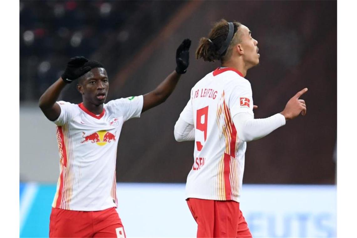 Leipzigs Yussuf Poulsen (r) jubelt nach seinem Tor zum 1:1 mit Amadou Haidara. Foto: Arne Dedert/dpa