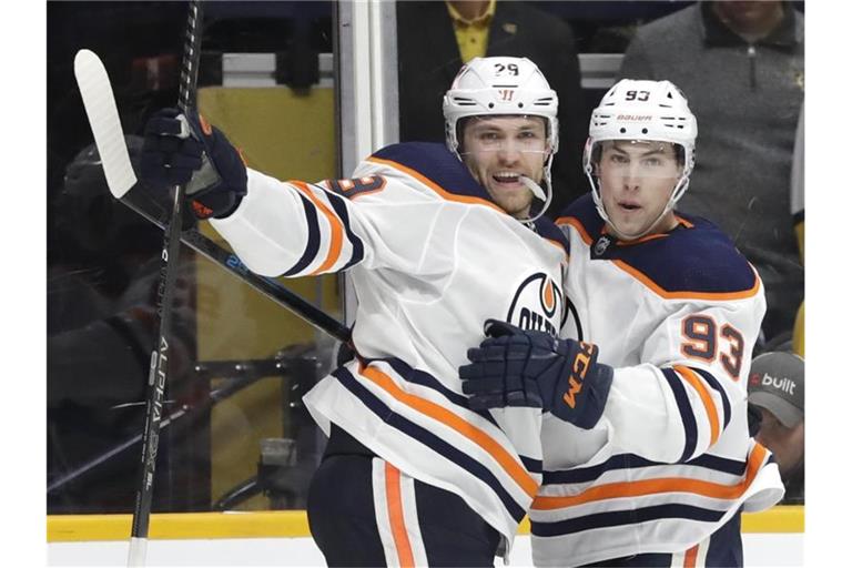 Leon Draisaitl (l) von den Edmonton Oilers ist der erste deutsche NHL-Topscorer. Foto: Mark Humphrey/AP/dpa