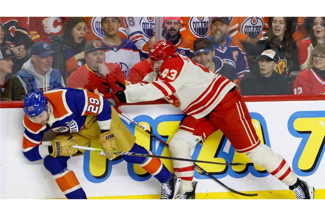 Leon Draisaitl (l.) von den Edmonton Oilers wird von Adam Klapka von den Calgary Flames attackiert.