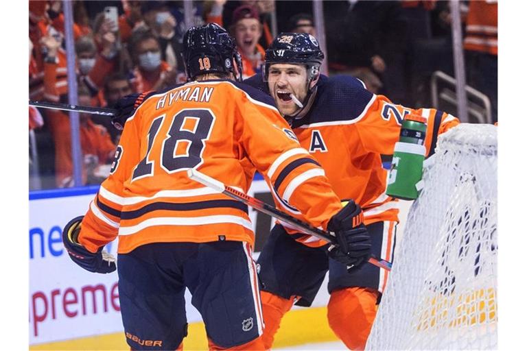 Leon Draisaitl (r) feiert mit Teamkollege Zach Hyman den Sieg der Edmonton Oilers. Foto: Jason Franson/The Canadian Press/AP/dpa