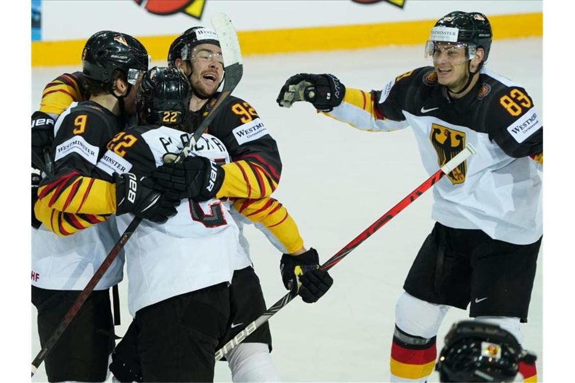 Dank „Briefmarken-Tor“: DEB-Team im Halbfinale Leon Gawanke (l) freut sich mit Mannschaftskameraden über sein Tor zum 2:2. Foto: Roman Koksarov/dpa