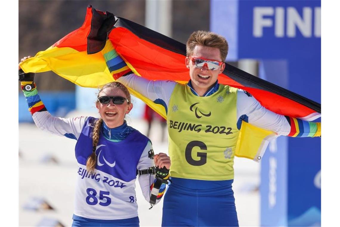 Leonie Walter und Guide Pirmin Strecker jubeln nach dem Zieleinlauf. Foto: Jens Büttner/dpa-Zentralbild/dpa
