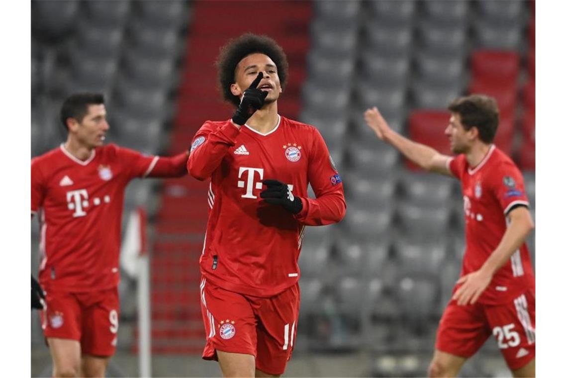 Leroy Sané (M) feiert sein Tor zum 3:0 für den FC Bayern, während hinter ihm Robert Lewandowski (l) und Thomas Müller abklatschen. Foto: Sven Hoppe/dpa