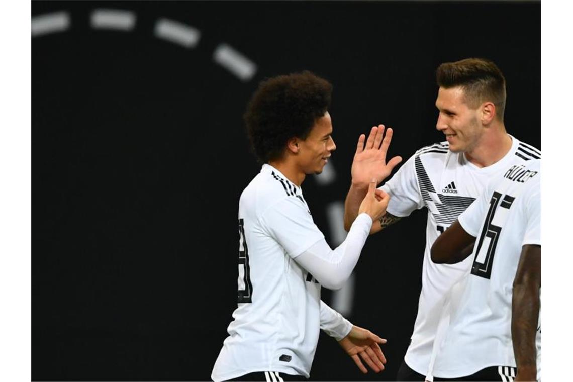 Flick zu möglichem Sané-Transfer: „Jetzt kein Thema“ Leroy Saneé (l) aus Deutschland und Niklas Süle jubeln über ein Tor. Foto: Soeren Stache/dpa/Archiv