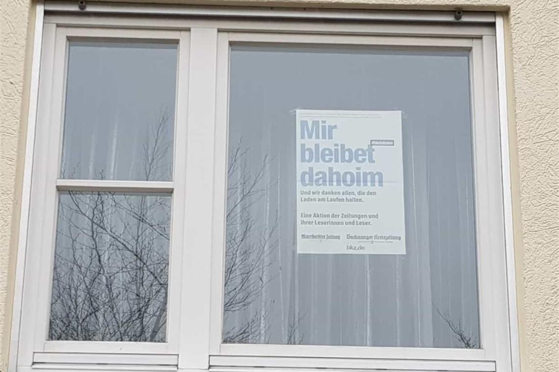 Plakat im Fenster: Wer bleibt alles dahoim?