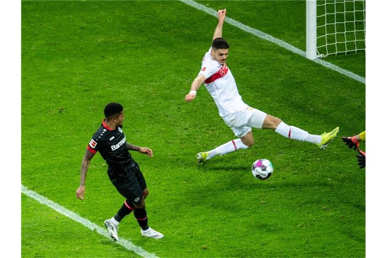 Leverkusens Bailey (v.l.) trifft gegen Stuttgarts Mavropanos und Torhüter Kobel zum 3:1. Foto: Marius Becker/dpa-Pool/dpa