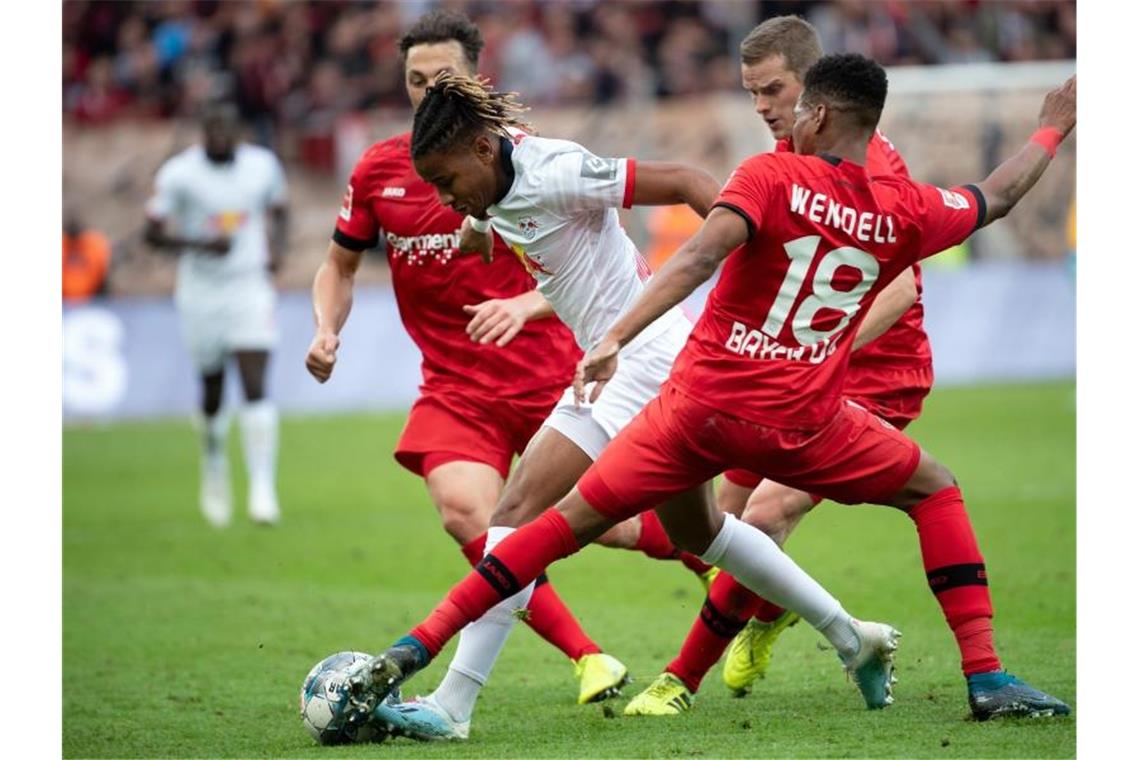 Erste Bayern-Heimpleite seit einem Jahr - S04 nur mit Remis Leverkusens Baumgartlinger, Bender und Wendell (l-r) versuchen Leipzigs Christopher Nkunku vom Ball zu trennen. Foto: Federico Gambarini/dpa