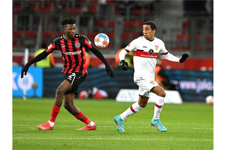 Leverkusens Edmond Tapsoba (l) und Stuttgarts Tiago Tomas kämpfen um den Ball. Foto: David Inderlied/dpa
