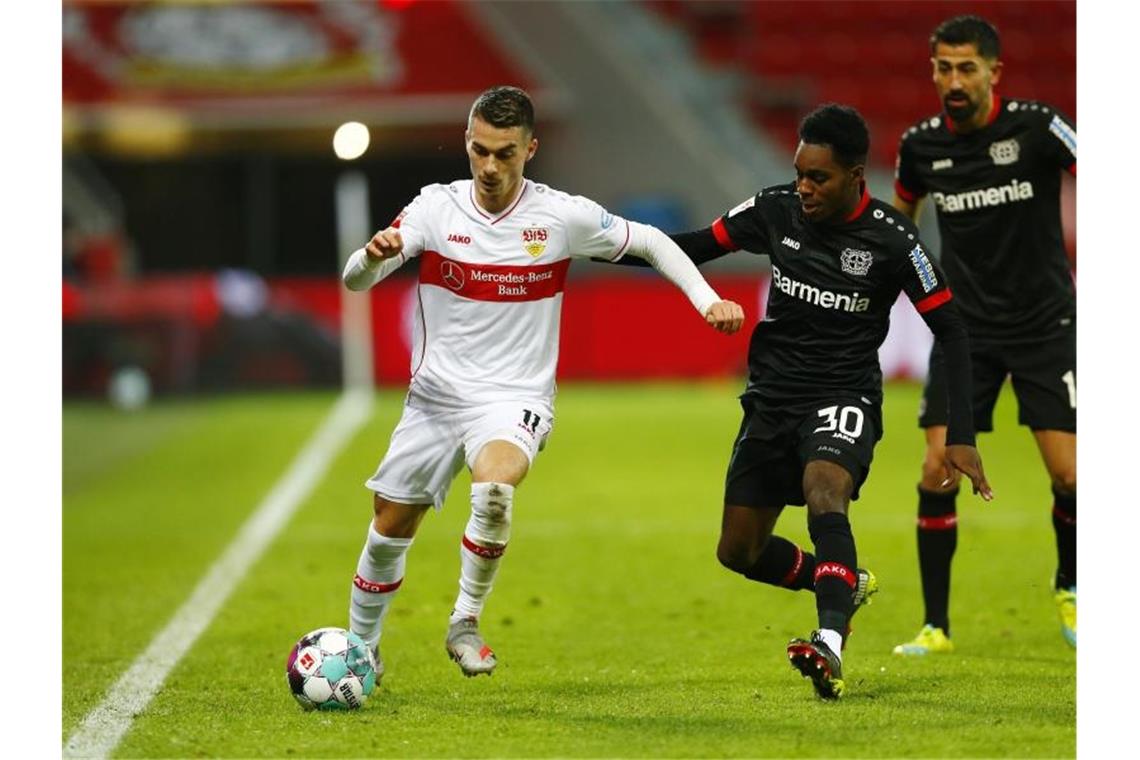 Leverkusens Jeremie Frimpong (M) und Stuttgarts Erik Thommy. Foto: Thilo Schmuelgen/Reuters/Pool/dpa