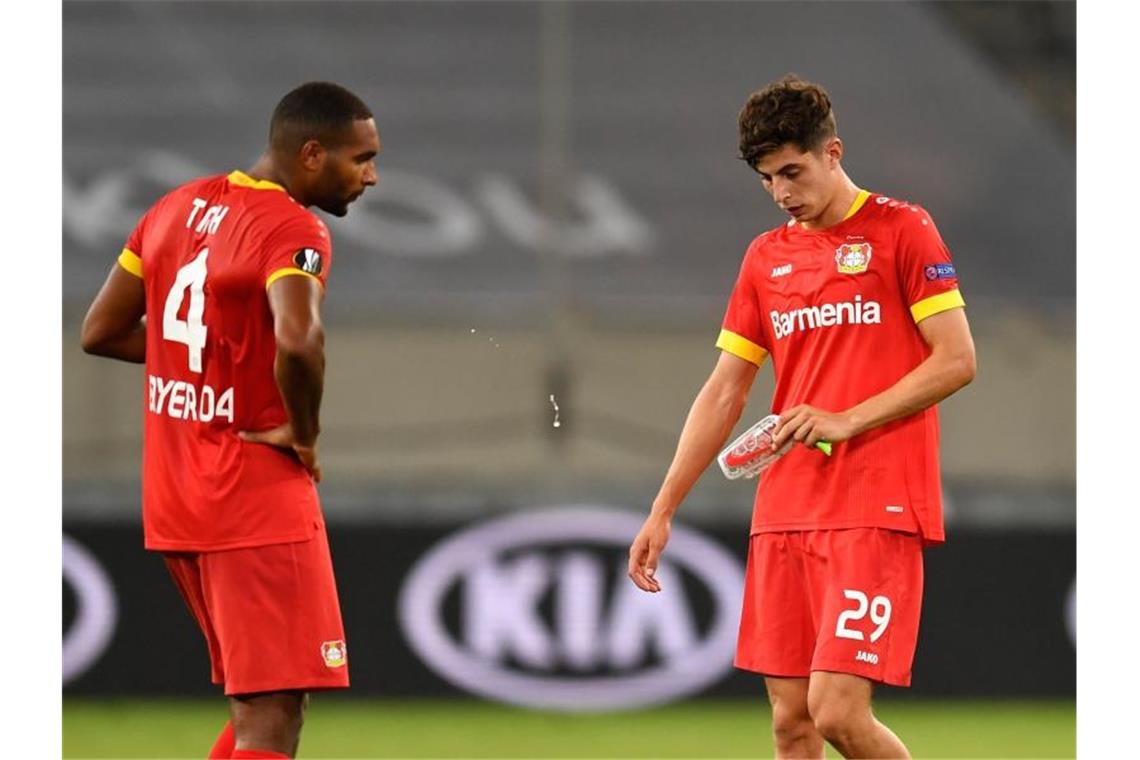 Leverkusens Jonathan Tah (l) und Kai Havertz stehen nach Abpfiff enttäuscht auf dem Platz. Foto: Marius Becker/dpa