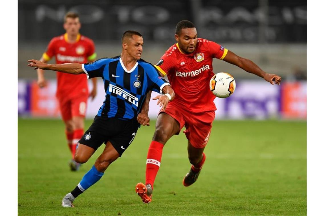 Leverkusens Jonathan Tah (r) und Alexis Sanchez von Inter Mailand kämpfen um den Ball. Foto: Marius Becker/dpa