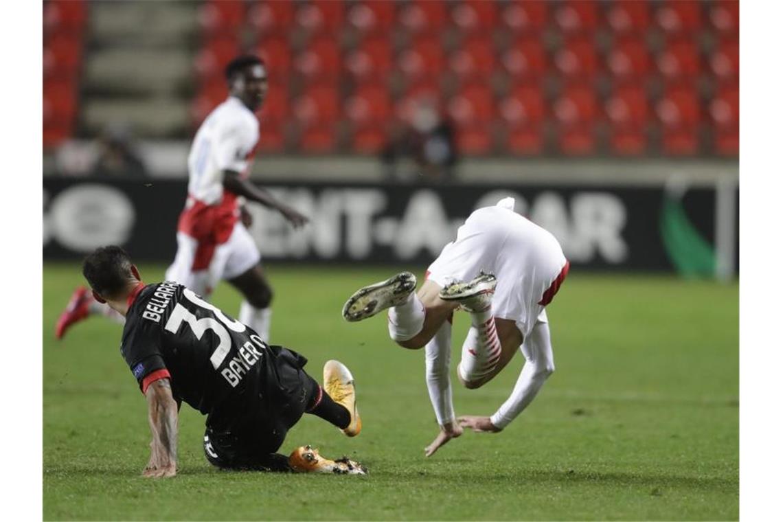 Leverkusens Karim Bellarabi (l) foult Slavias Lukas Provod und kassiert im Anschluss die Rote Karte. Foto: Petr David Josek/AP/dpa