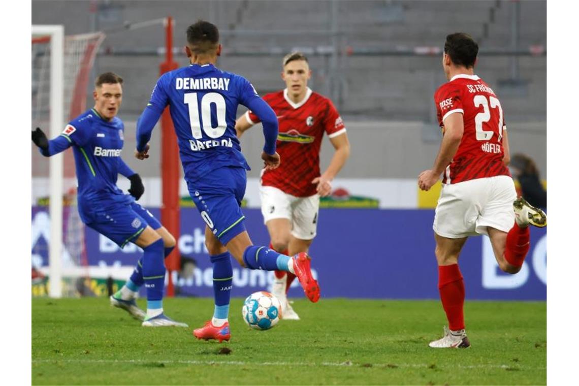 Hoffenheim und Freiburg kämpfen um DFB-Pokal-Viertelfinale Leverkusens Kerem Demirbay (10, 2.v.l.) spielt den Ball zu Leverkusens Florian Wirtz (l), während Freiburgs Nico Schlotterbeck und Freiburgs Nicolas Höfler (r) versuchen, den Ball zu erreichen. Foto: Philipp von Ditfurth/dpa/Archivbild